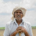 Elderly farmer standing in a field in Amaravati, AP, India. Portrait captures rural life.